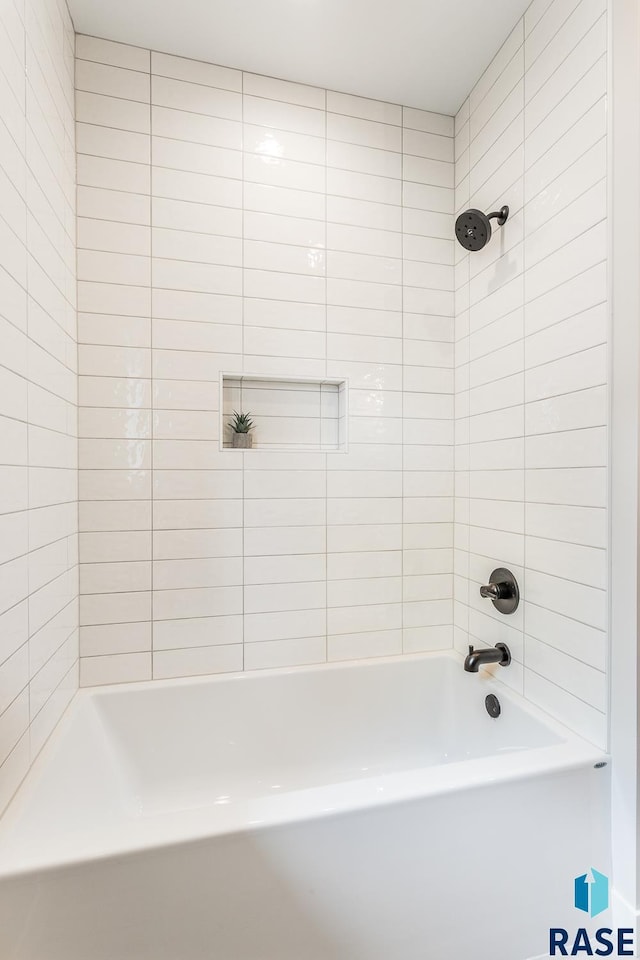 bathroom featuring tiled shower / bath