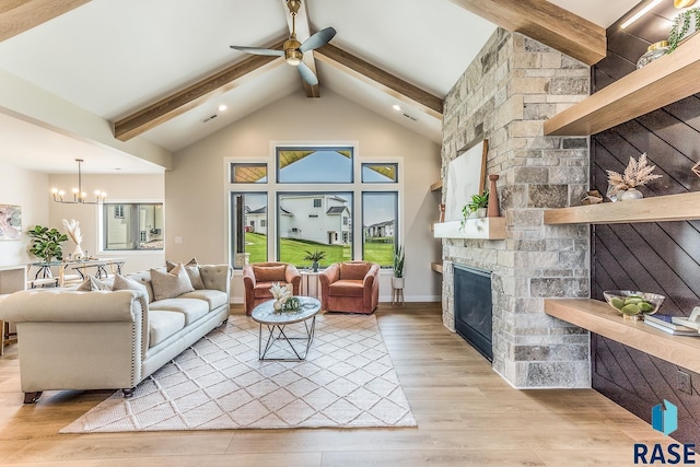 living room featuring a stone fireplace, light hardwood / wood-style flooring, ceiling fan with notable chandelier, and vaulted ceiling with beams