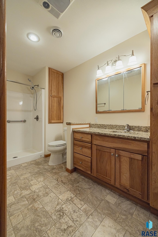 bathroom featuring a shower, vanity, and toilet