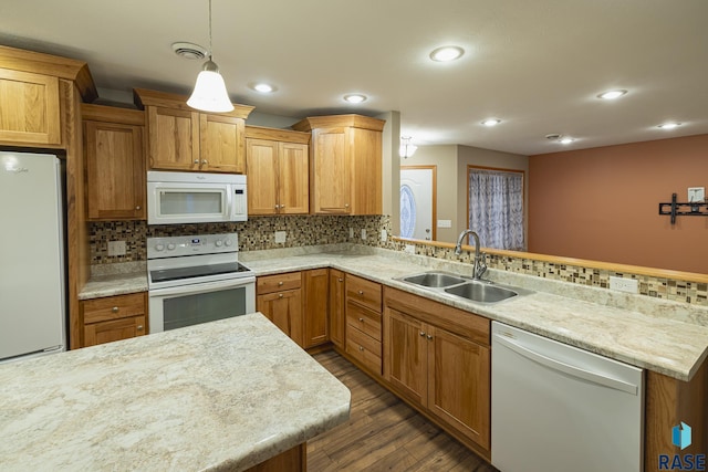 kitchen featuring sink, dark hardwood / wood-style flooring, decorative light fixtures, white appliances, and decorative backsplash