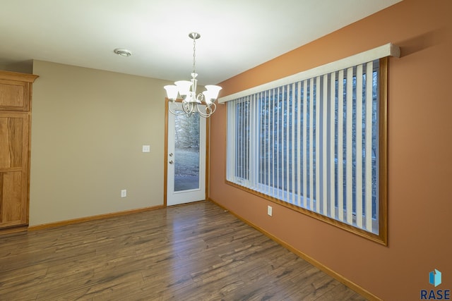 unfurnished room featuring dark hardwood / wood-style flooring and a notable chandelier