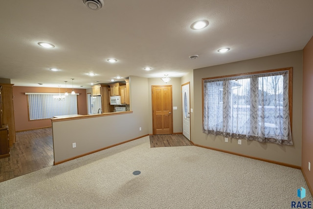 empty room with light carpet and a chandelier