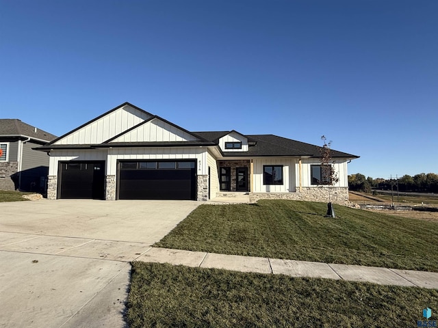 modern farmhouse style home with a garage, driveway, stone siding, and a front yard