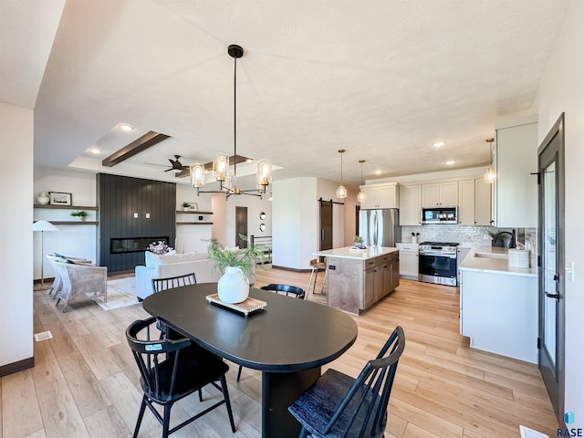 dining space featuring light wood-style floors, recessed lighting, ceiling fan, and baseboards