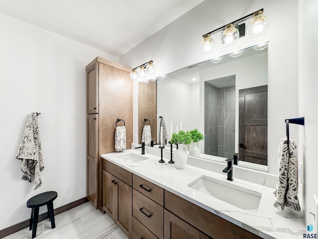 full bathroom featuring a sink, baseboards, and double vanity