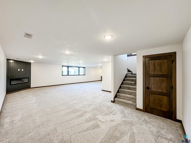 below grade area featuring stairway, carpet, visible vents, and baseboards