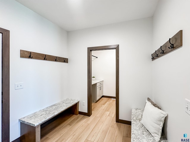 mudroom featuring light wood-style flooring and baseboards