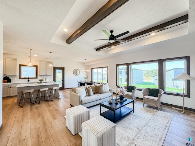 living area featuring beam ceiling, light wood finished floors, recessed lighting, a ceiling fan, and baseboards