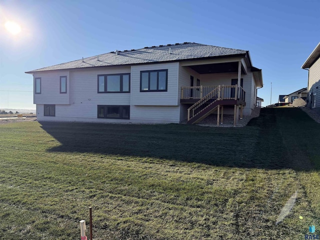 rear view of property with stairs and a yard