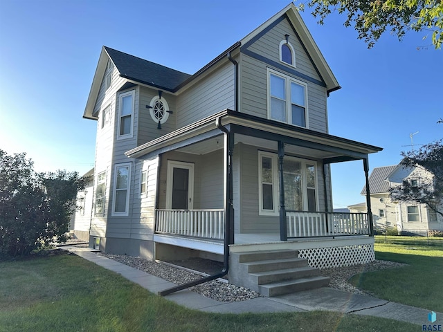 view of front facade featuring covered porch and a front yard