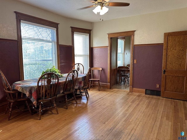 dining space with ceiling fan and light wood-type flooring