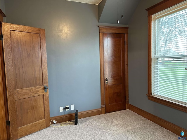 unfurnished bedroom with carpet floors and vaulted ceiling