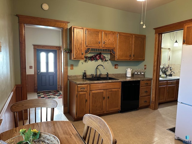 kitchen with light tile patterned floors, black dishwasher, white fridge, and sink