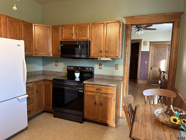 kitchen with white refrigerator, black electric range oven, and ceiling fan