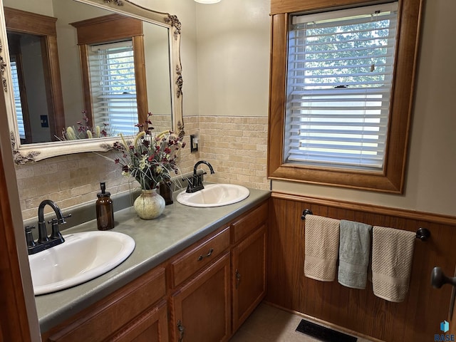 bathroom with tile patterned floors, vanity, and a healthy amount of sunlight