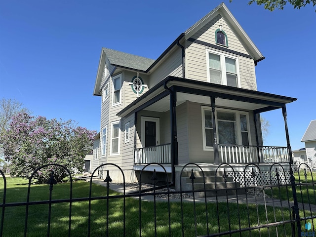 view of front of house featuring covered porch and a front yard