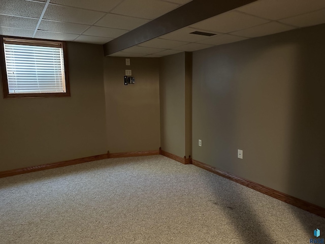 basement with a paneled ceiling and carpet floors