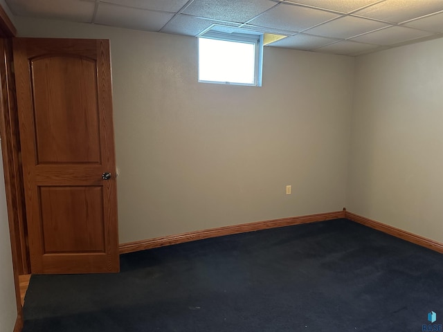 carpeted spare room featuring a paneled ceiling