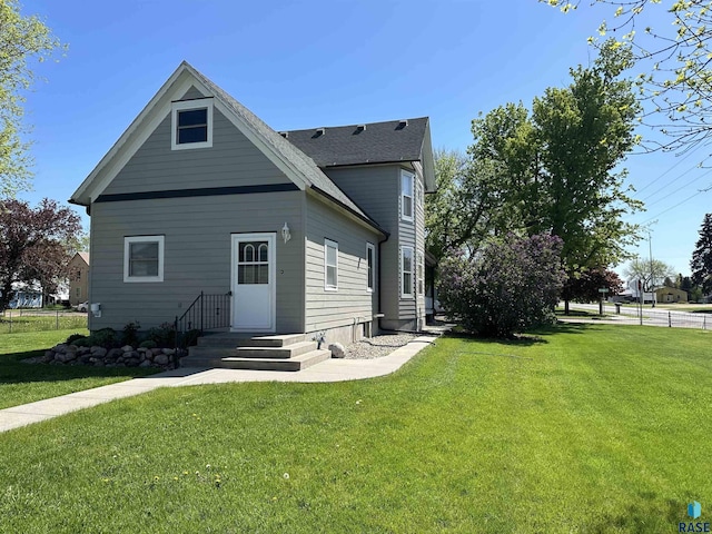 rear view of property with a lawn