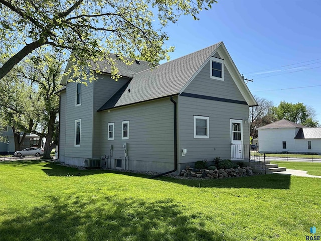 view of side of home featuring central AC and a yard