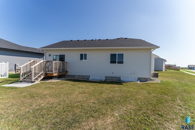 rear view of house featuring a lawn, cooling unit, and a wooden deck