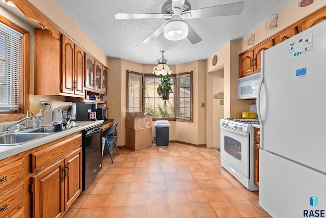 kitchen featuring a textured ceiling, white appliances, ceiling fan, and sink