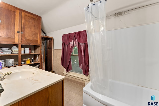 bathroom with shower / bath combo with shower curtain, vanity, and lofted ceiling