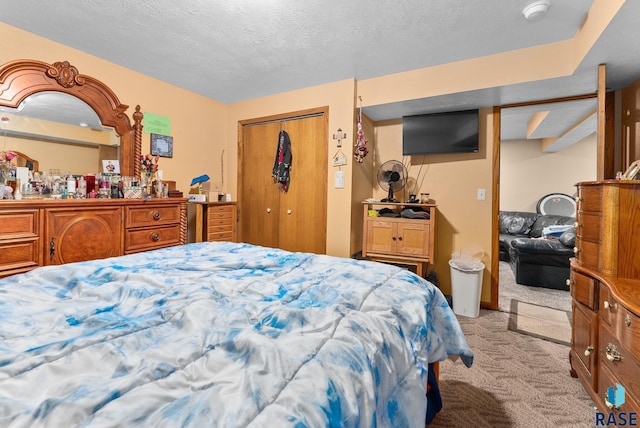 carpeted bedroom with a textured ceiling and a closet