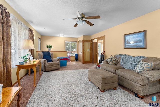 living room with carpet, ceiling fan, and a textured ceiling