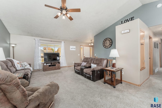 carpeted living room with ceiling fan and vaulted ceiling