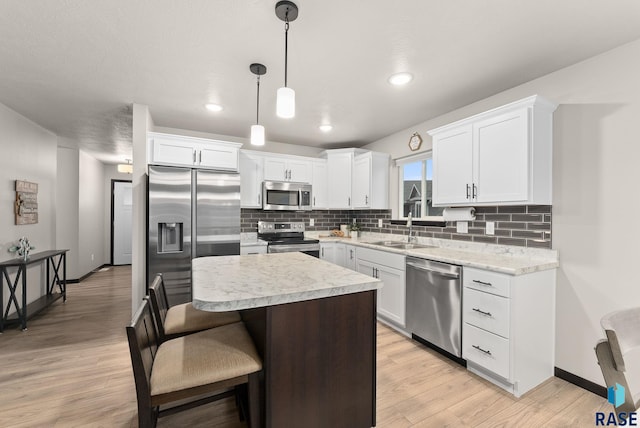 kitchen with white cabinets, sink, a kitchen island, and stainless steel appliances