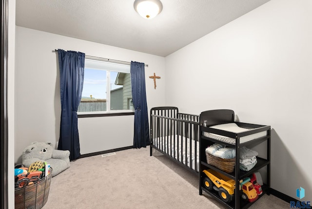 bedroom with a crib and light carpet