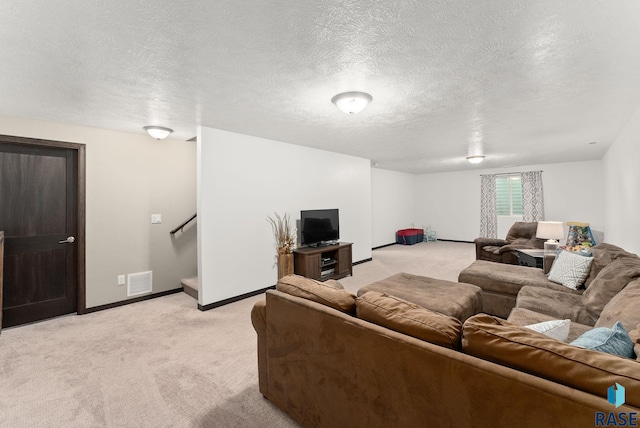 carpeted living room featuring a textured ceiling