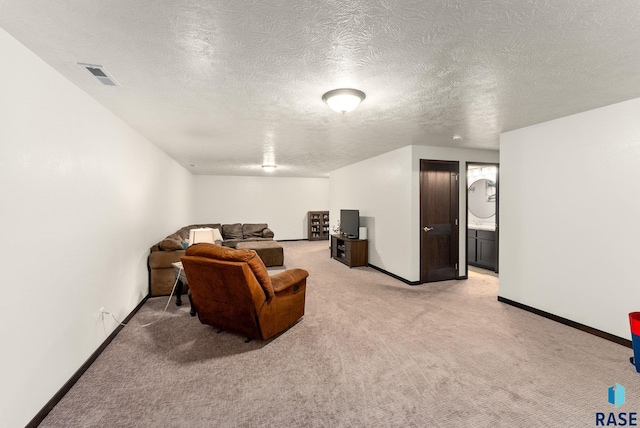 living area with light colored carpet and a textured ceiling