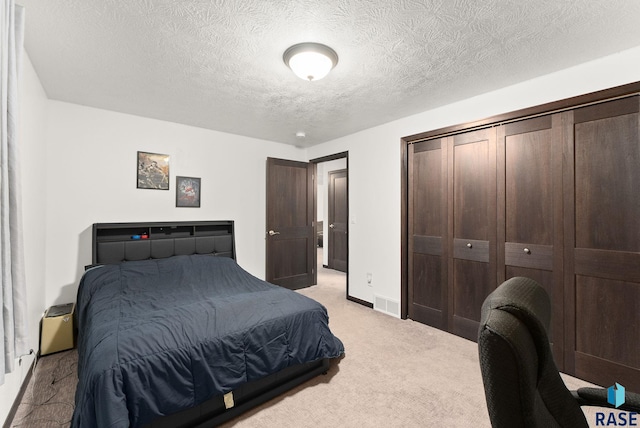 bedroom with a textured ceiling and light carpet