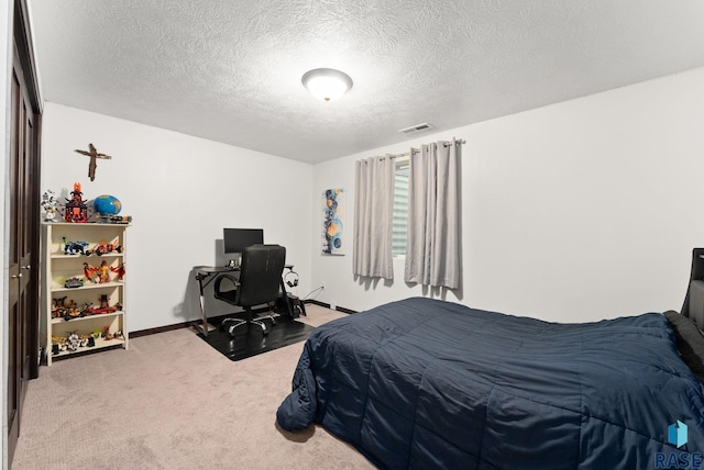 bedroom featuring carpet floors and a textured ceiling