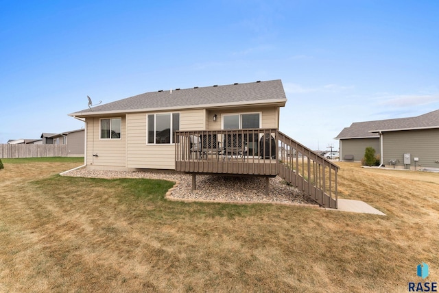 rear view of property with a deck and a yard