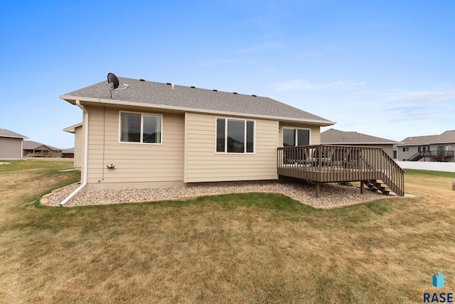 back of property featuring a lawn and a deck