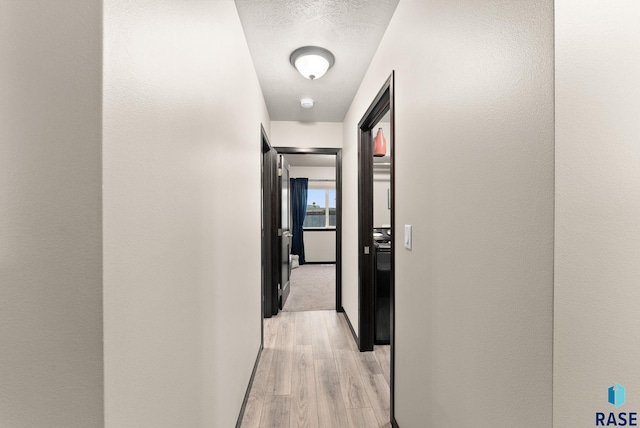 hallway with light hardwood / wood-style floors