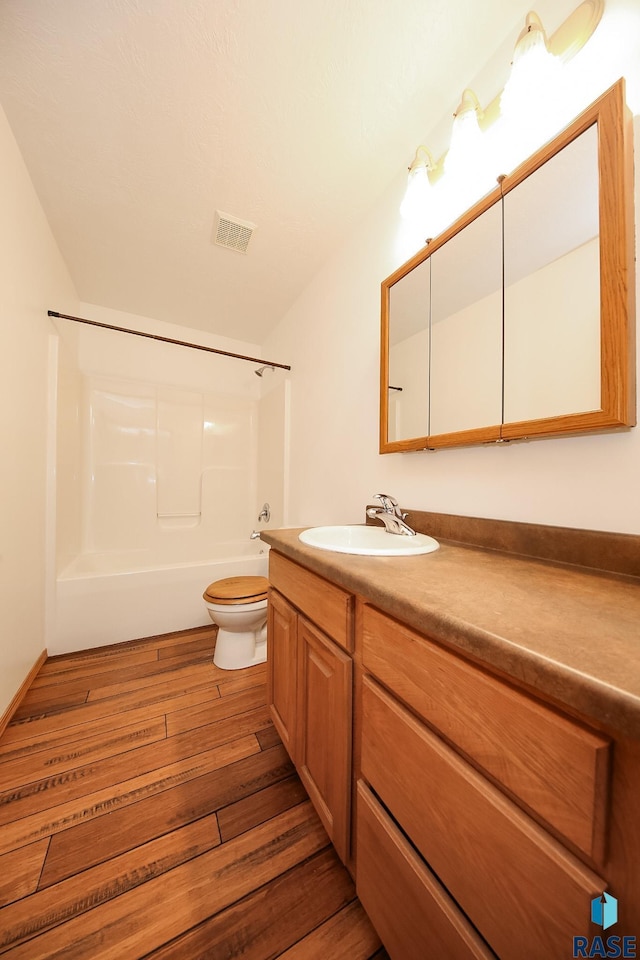 full bathroom with toilet, vanity, shower / bathtub combination, and hardwood / wood-style flooring