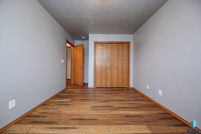 unfurnished bedroom featuring light hardwood / wood-style floors and a textured ceiling