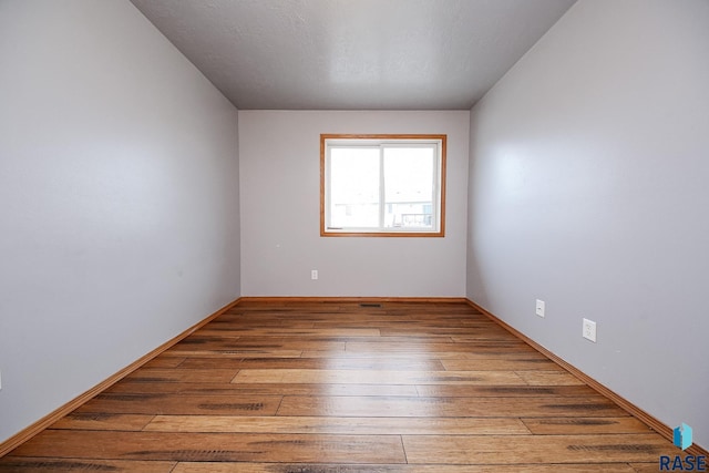 unfurnished room with hardwood / wood-style floors