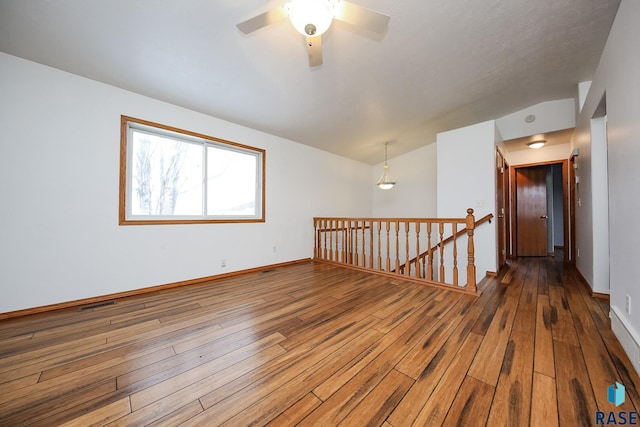 spare room featuring lofted ceiling, ceiling fan, and wood-type flooring