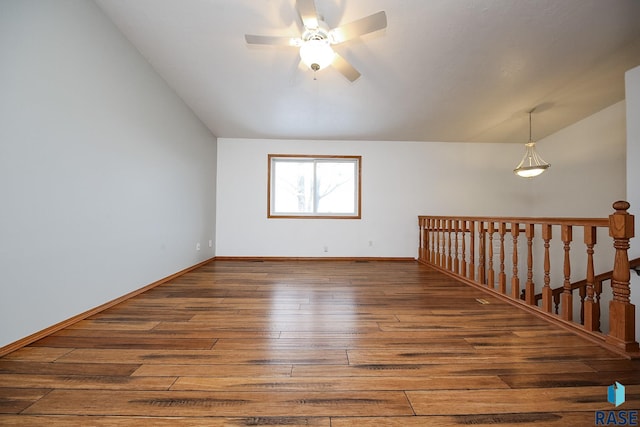 spare room with wood-type flooring, vaulted ceiling, and ceiling fan