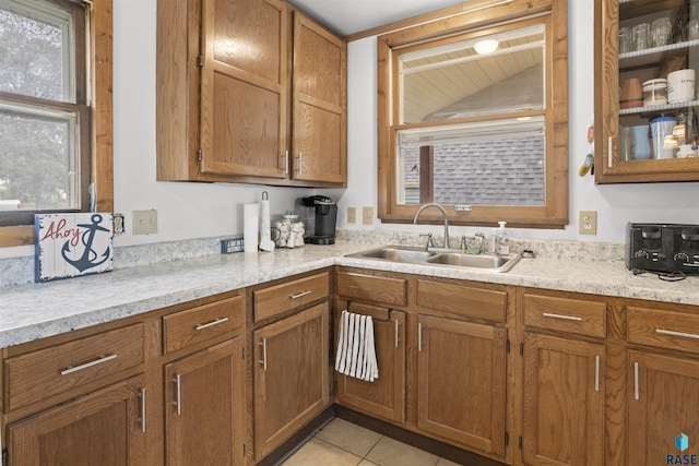 kitchen with light stone countertops, light tile patterned floors, and sink