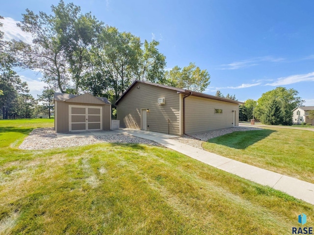 view of property exterior with a lawn, a garage, and an outbuilding