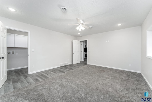 carpeted spare room featuring ceiling fan and a textured ceiling