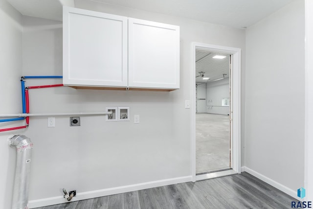 clothes washing area with washer hookup, hookup for an electric dryer, cabinets, and light wood-type flooring