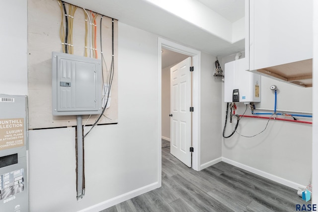 washroom with light wood-type flooring, electric panel, and water heater