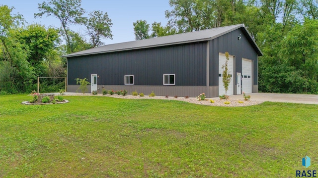 view of home's exterior with a lawn, an outdoor structure, and a garage